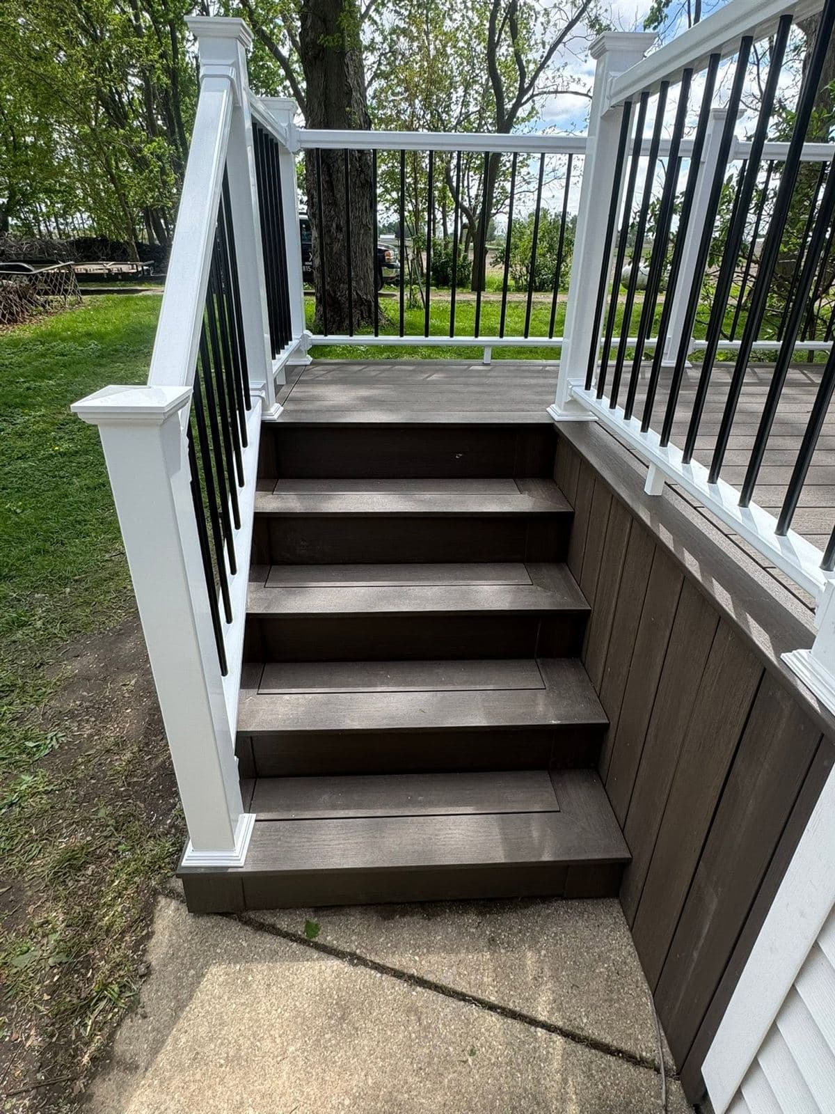 Composite deck stairs with white railing and black aluminum balusters