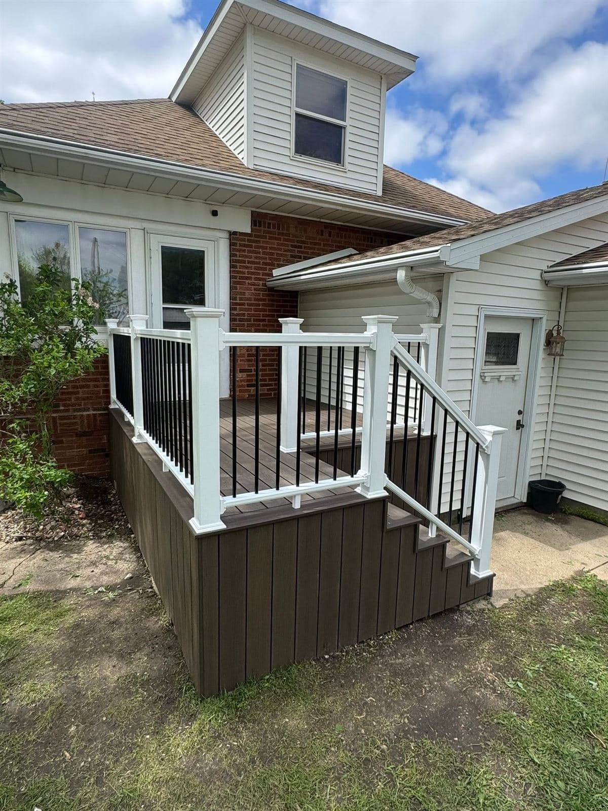 Completed composite deck with white railing on a farmhouse