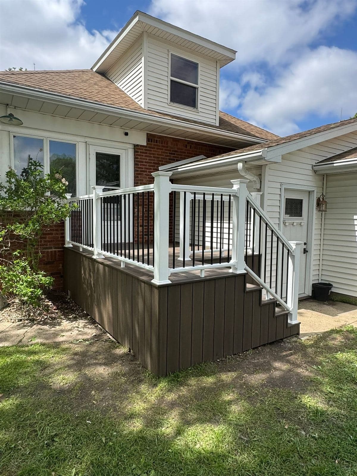 Composite deck with white railing and dark skirting