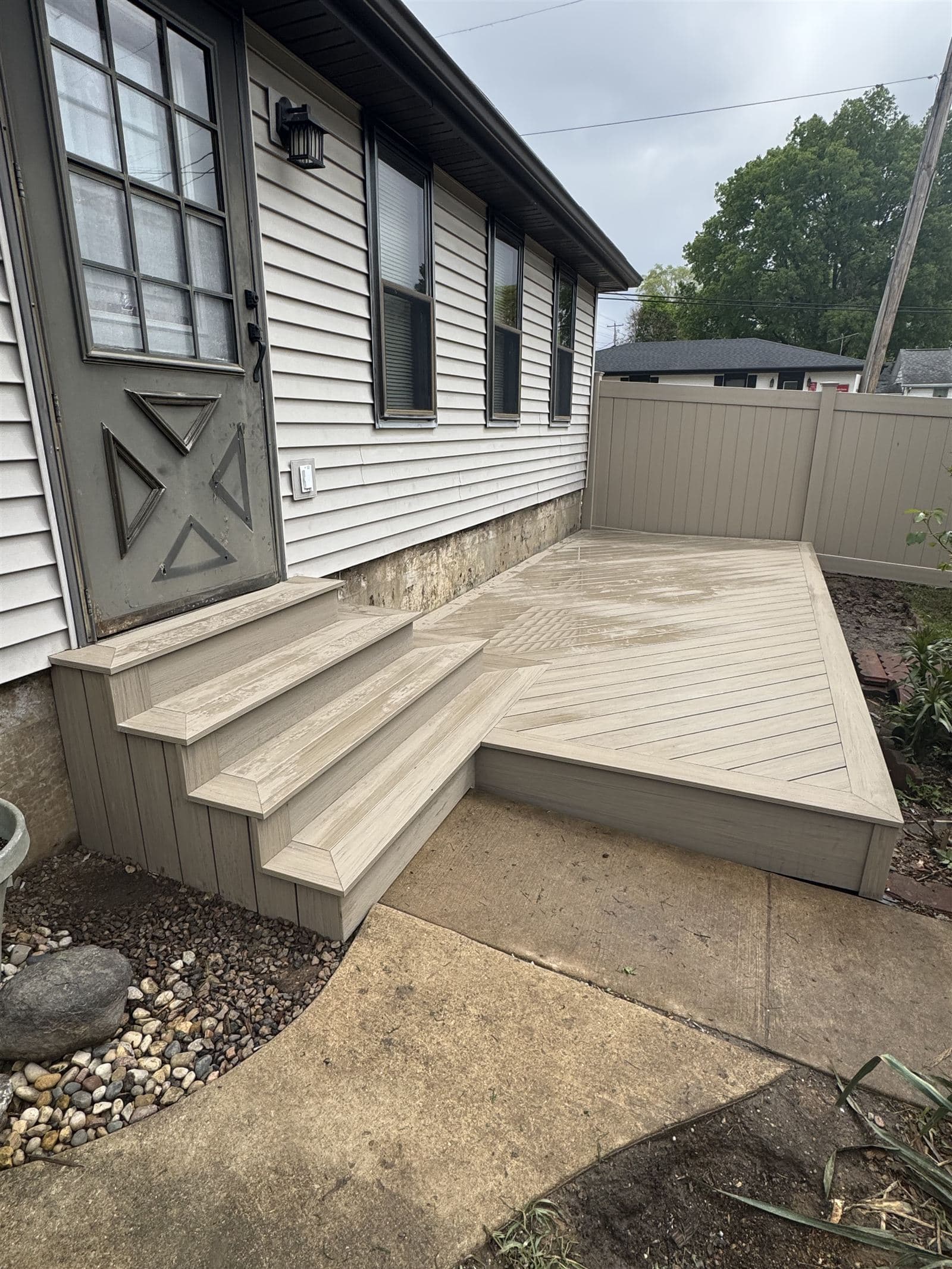 Ground level composite deck with diagonal board pattern and wrapped box steps