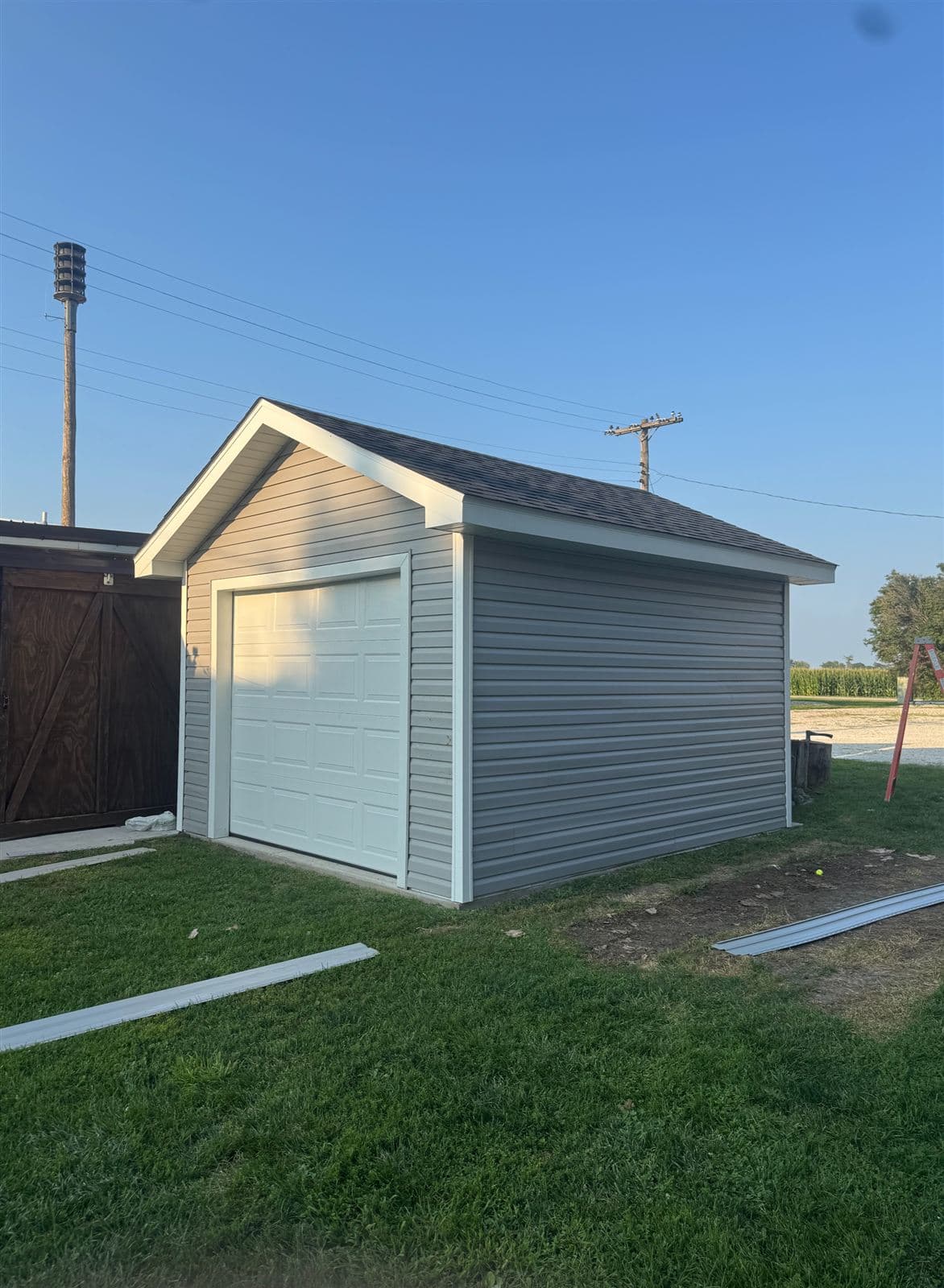New backyard shed with fresh siding and garage door