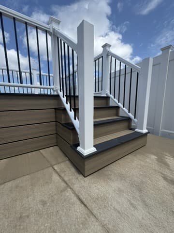 Composite deck stairs with white posts and black balusters