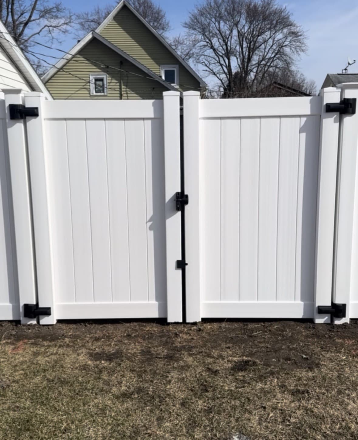 White vinyl double gate with black strap hinges and cross-braced leaves, built by Xcel Outdoor Living