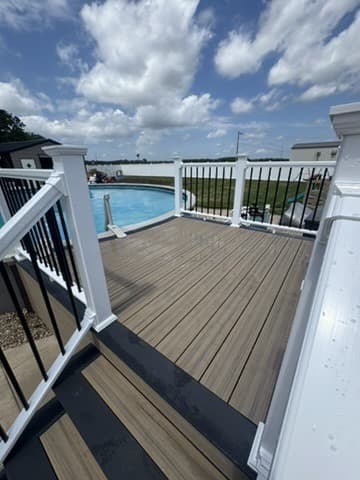 Composite pool deck with white railing and black balusters