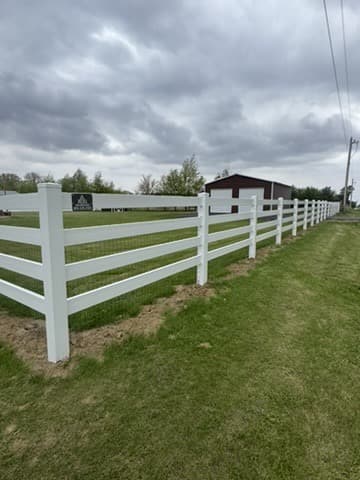 White four rail ranch fence running across open lawn